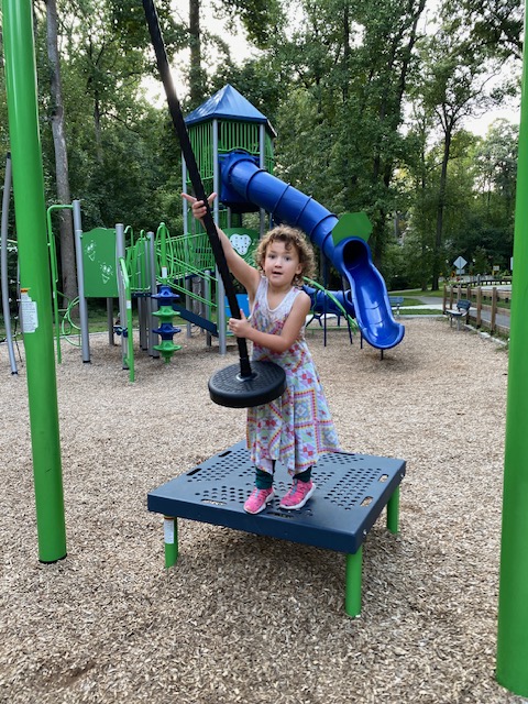 Addy about to get on the zip line at a Sligo Creek Parkway playground