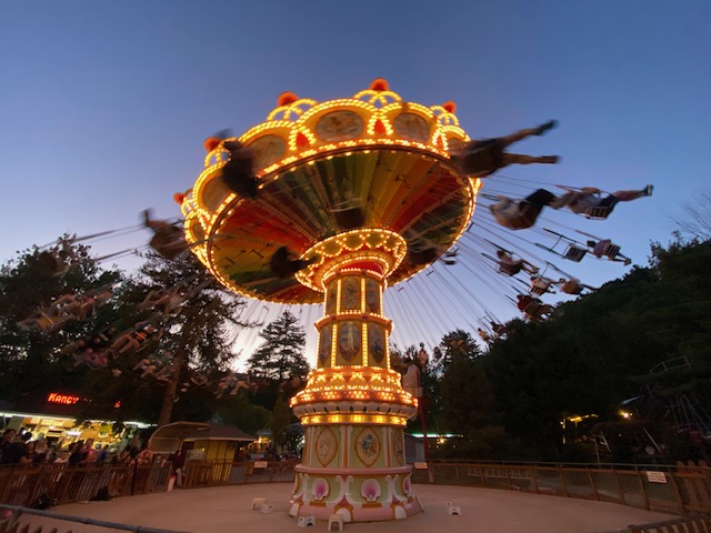 People are blurry on the Swings ride, which is lit up at Knoebels Amusement Park.